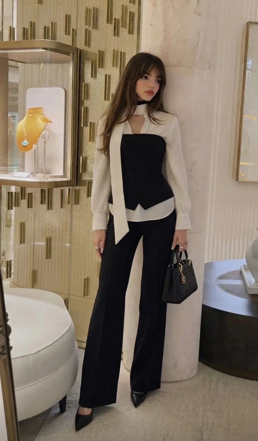 Women's autumn outfit: white blouse with a black corset vest and wide tailored trousers