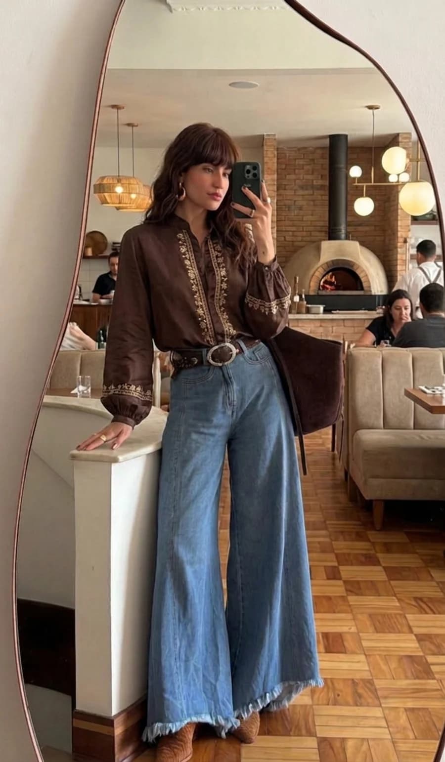 Dinner date outfit: wide-leg light jeans with an embroidered silk blouse and heeled boots