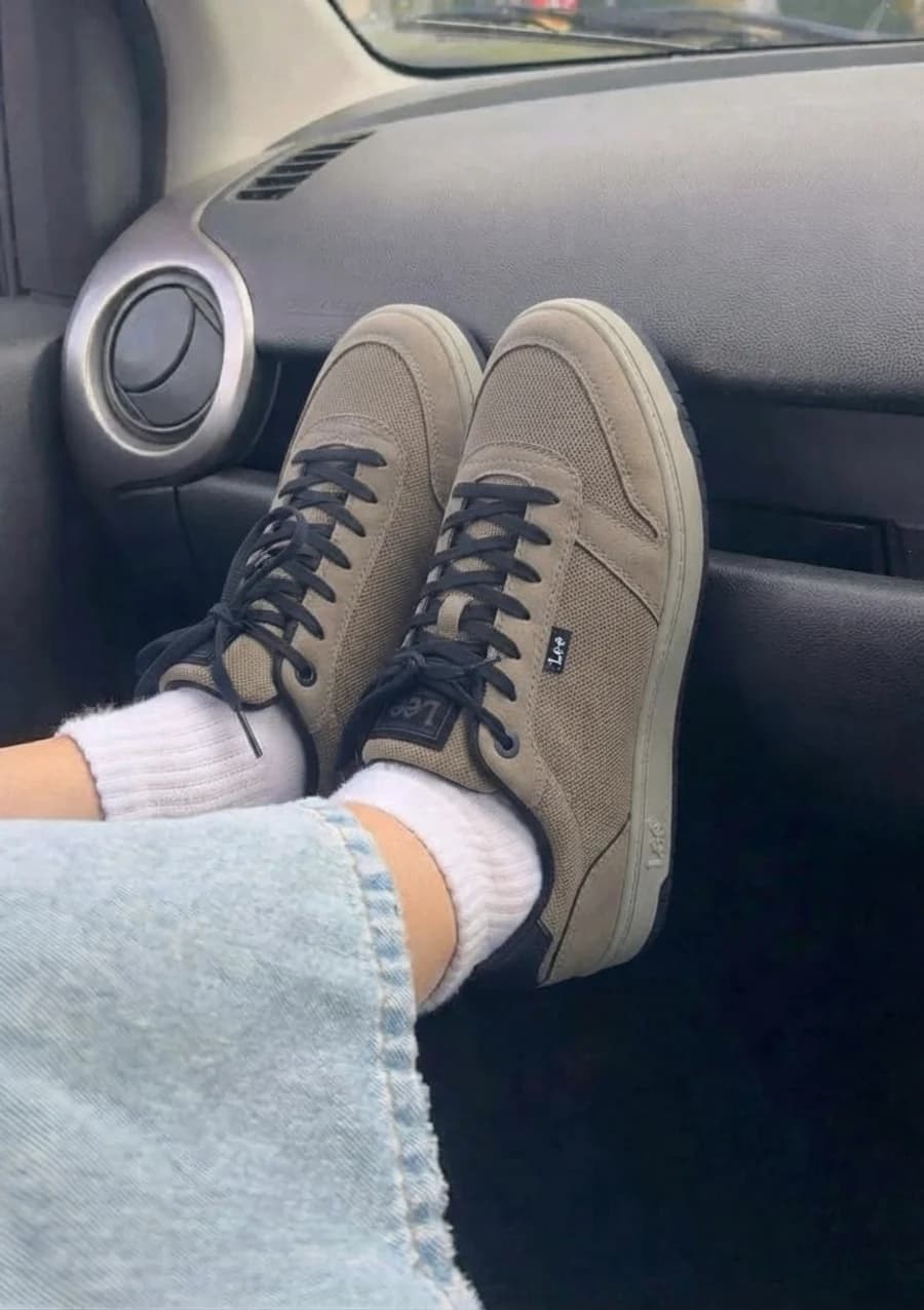 Men's olive green casual sneakers with light-wash jeans and white socks