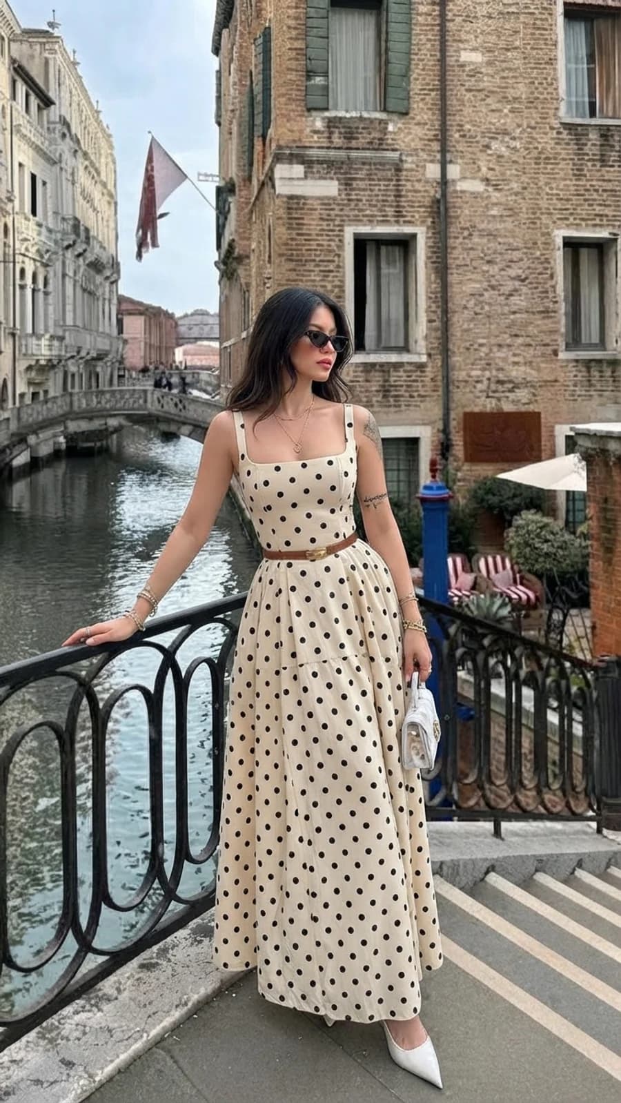 City break vacation outfit: cream polka-dot maxi dress with a tan belt and white kitten heels in Venice