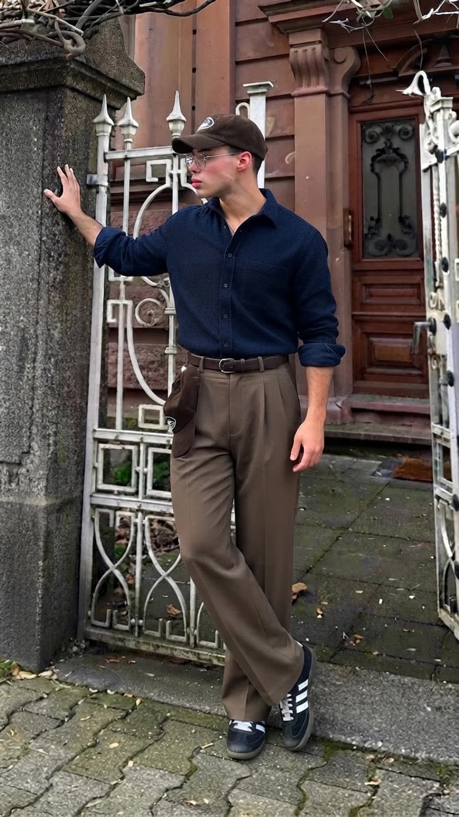 Dressier weekend look: navy overshirt buttoned and tucked into brown pleated wide chinos with black trainers
