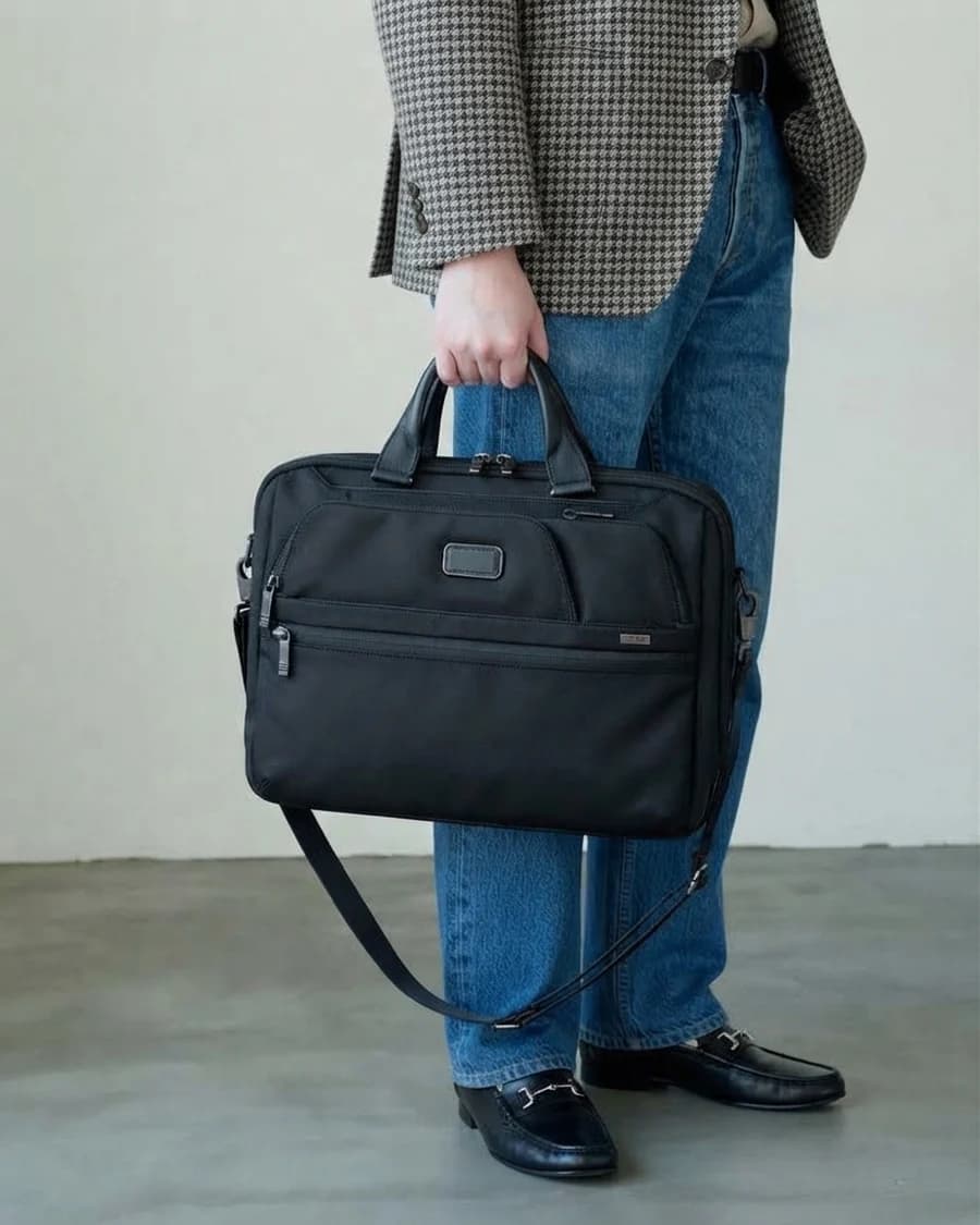 TUMI black laptop briefcase with a houndstooth blazer and denim