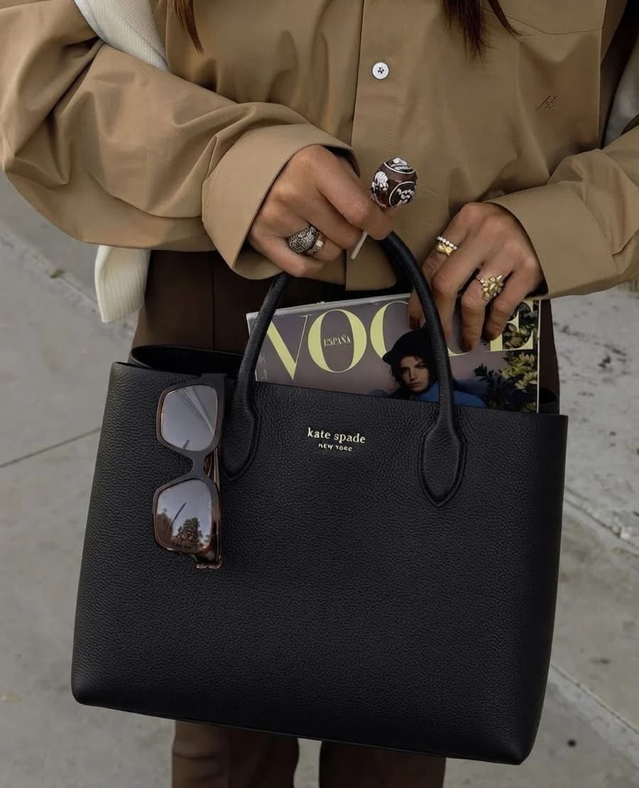 Kate Spade black pebbled leather tote with a camel shirt and stacked rings
