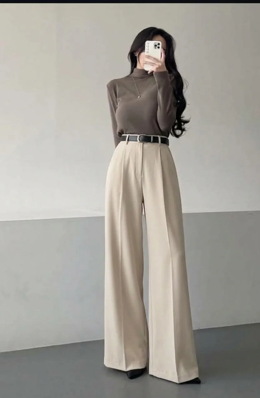 High-waisted beige wide-leg trousers with a black belt and a taupe turtleneck