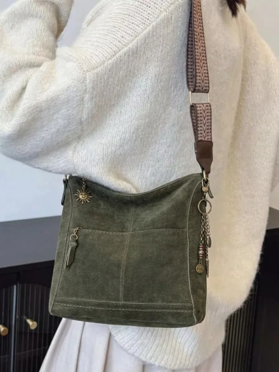 Olive suede crossbody bag with a woven strap and small charms