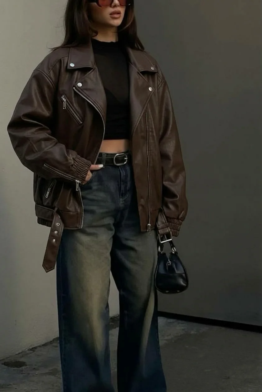 Oversized brown moto jacket over a black top and faded wide jeans