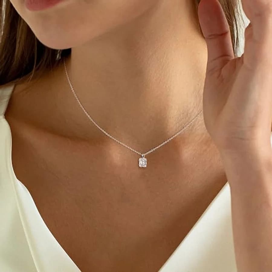 Fine silver chain with an emerald-cut solitaire pendant on a cream V-neck
