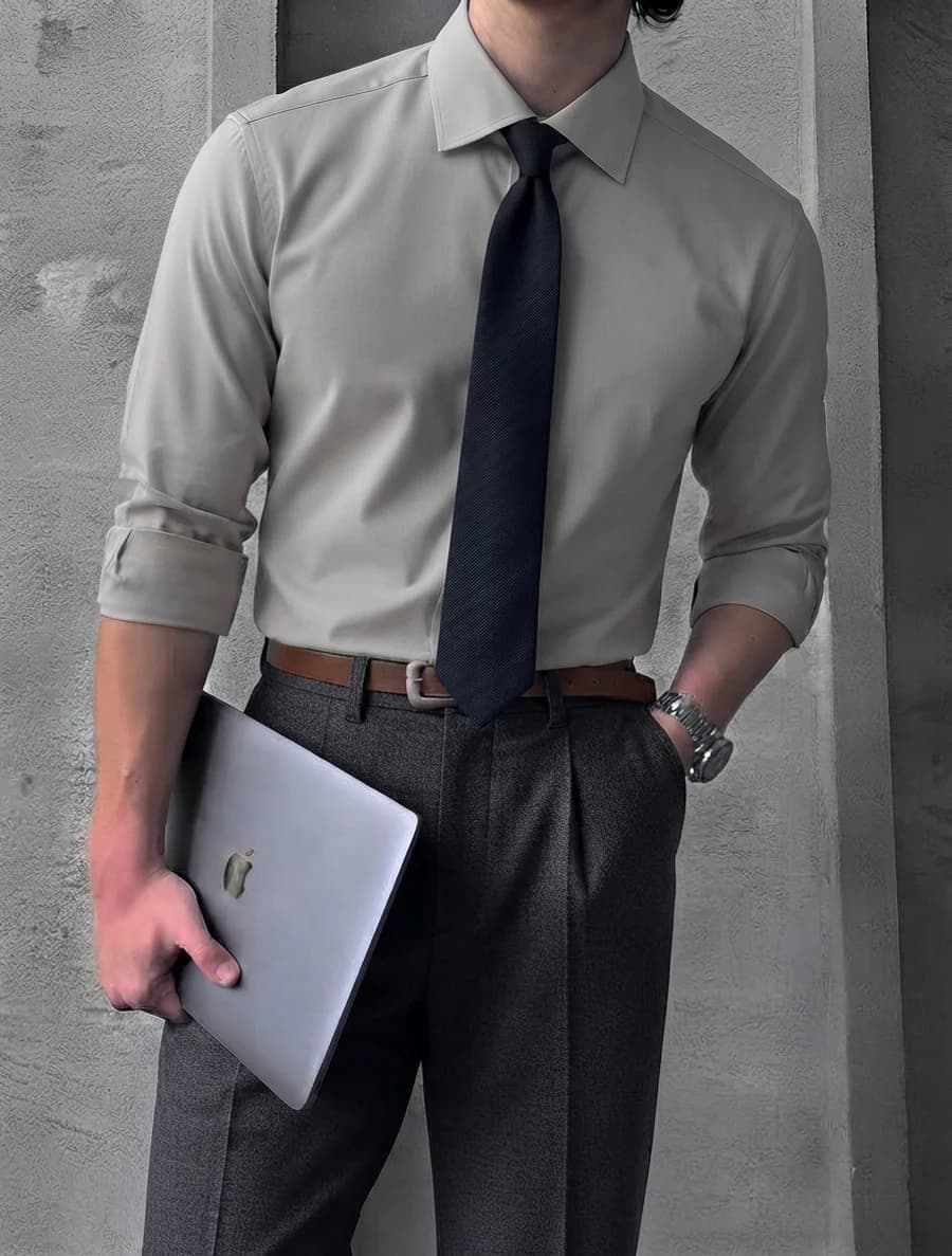 Modern office outfit: stone shirt with navy tie, charcoal pleated trousers and rolled sleeves