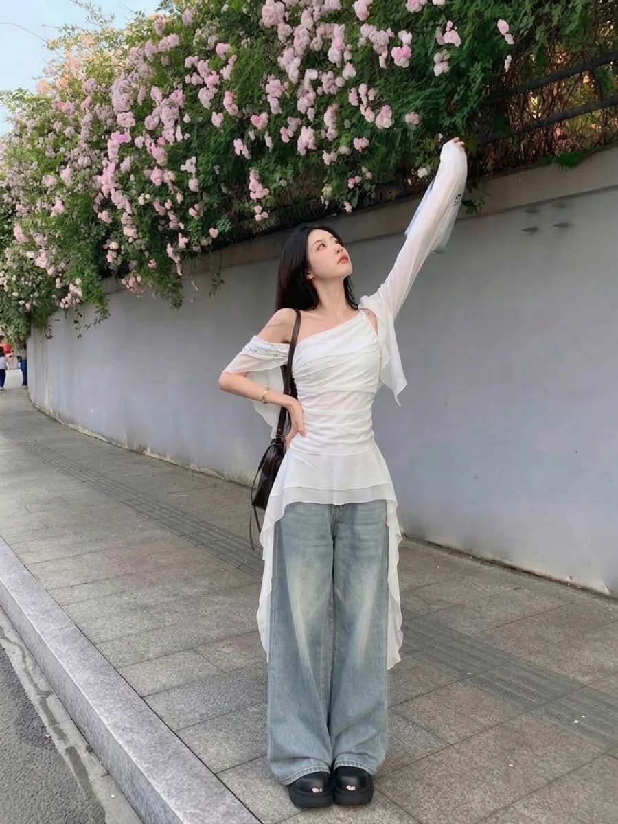 Women's spring outfit: sheer white tunic over wide light-wash jeans
