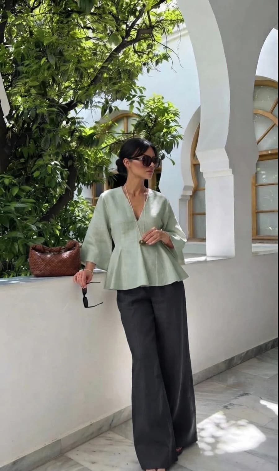 Linen two-piece vacation outfit: sage peplum top with charcoal wide linen trousers and a woven bag