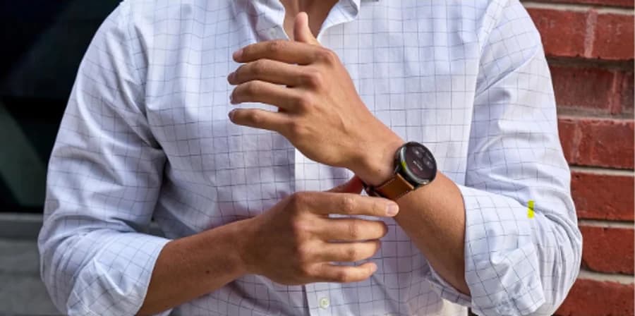 Garmin Venu smartwatch with a brown leather strap worn with a windowpane shirt