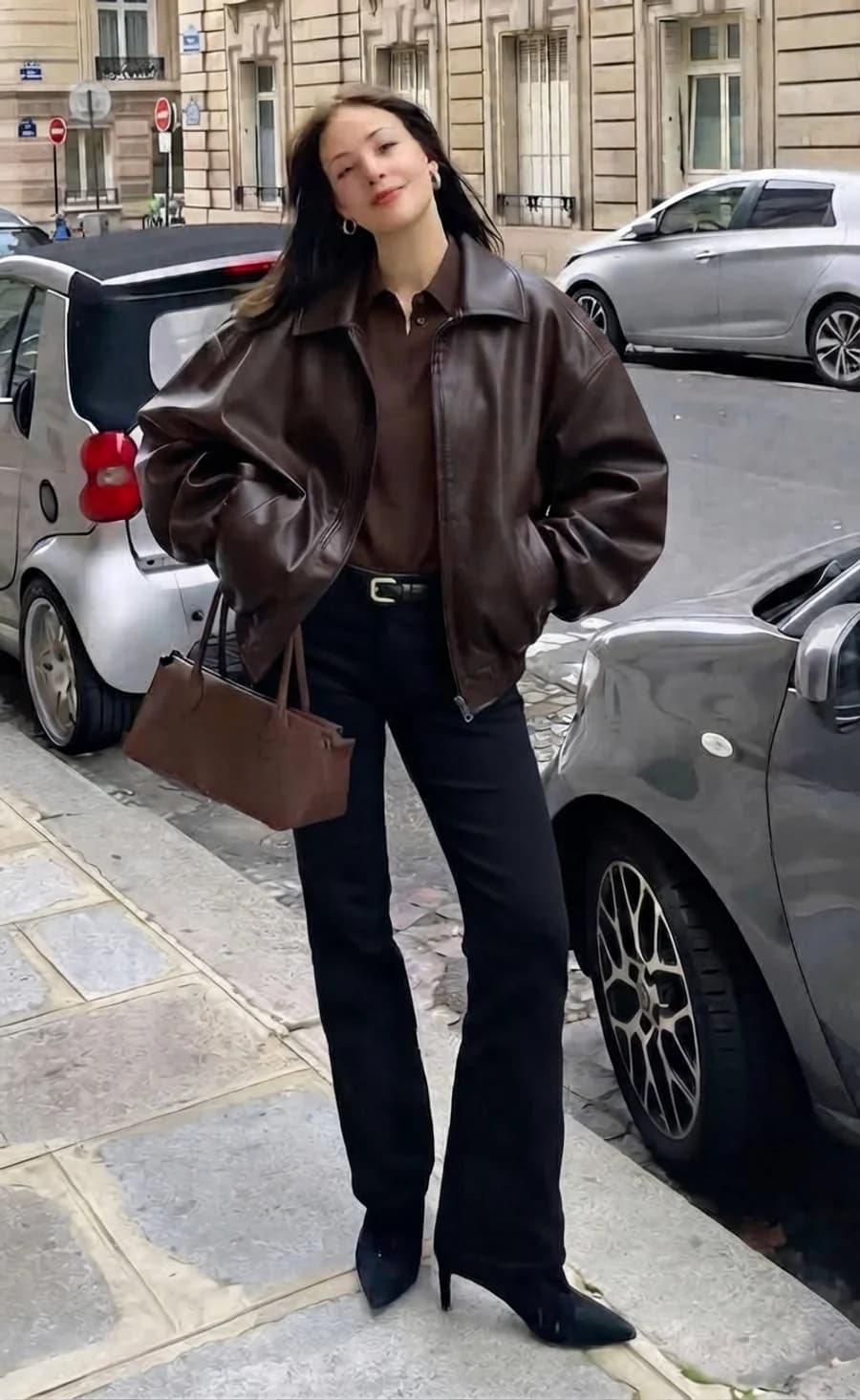Women's winter outfit: brown leather bomber with black straight trousers and heeled boots