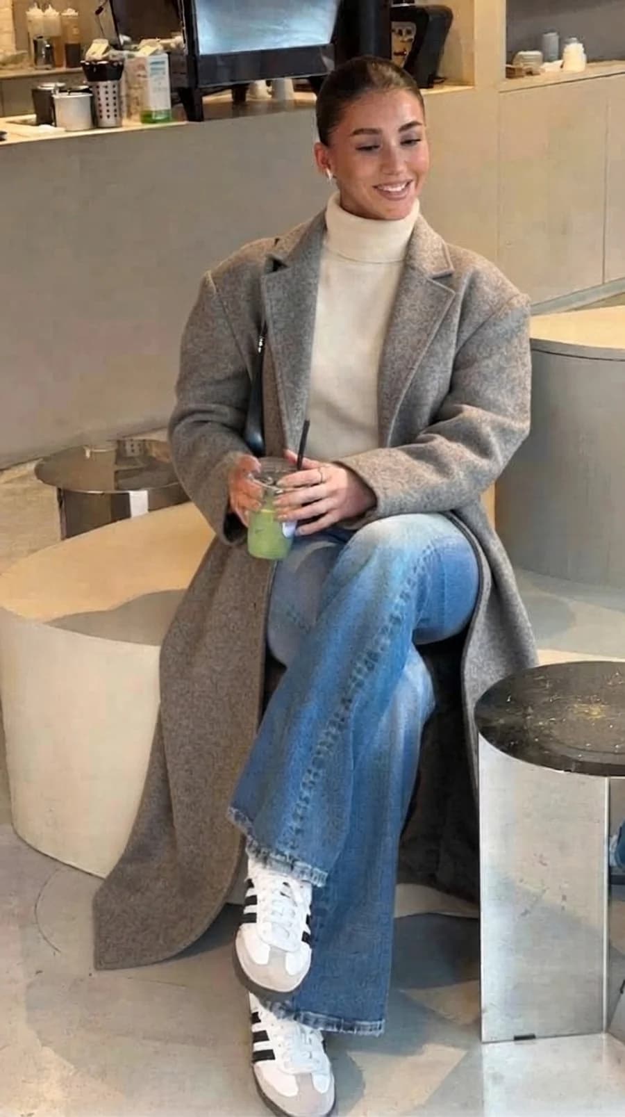 Women's winter outfit: grey wool overcoat with cream turtleneck and wide-leg jeans